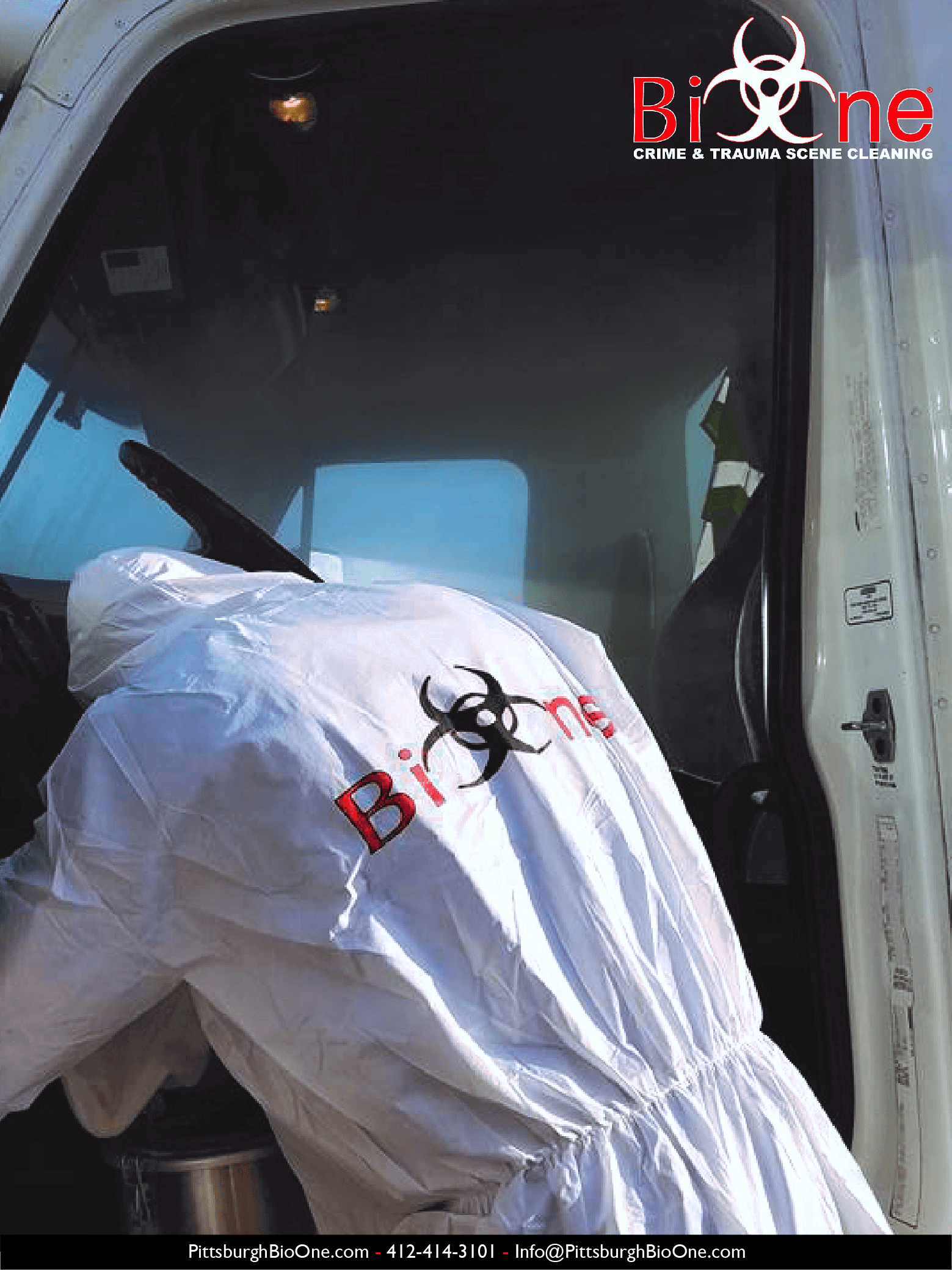 Image shows Bio-One technician dressed in hazmat and PPE cleaning an emergency vehicle (ambulance).